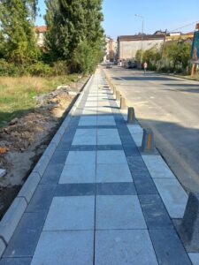 Beyaz renkli, kumlamalı yüzeye sahip kare şeklinde beton plaka taşı.