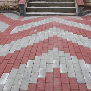 Kırmızı renkli, dikdörtgen prizma şeklindeki beton parke taşının kesit görseli.