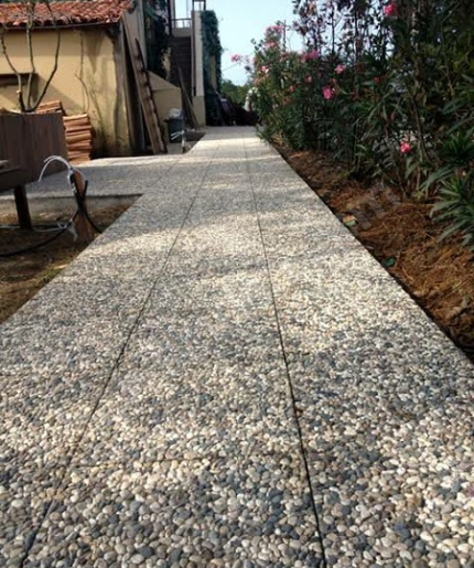 40x40x4 cm karışık renkli çakıllarla kaplanmış wash beton karoların palet stok görünümü ve dış mekan zemin uygulaması (dama deseni, bahçe yolu).