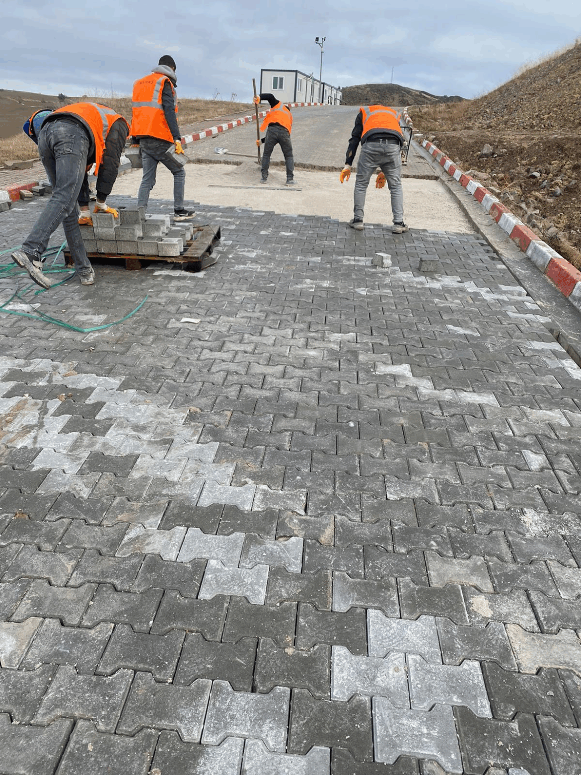 İşçiler tarafından döşenen gri 8 cm ağır yük kilitli parke taşları