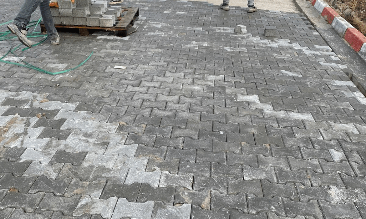 İşçiler tarafından döşenen gri 8 cm ağır yük kilitli parke taşları