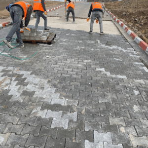 İşçiler tarafından döşenen gri 8 cm ağır yük kilitli parke taşları