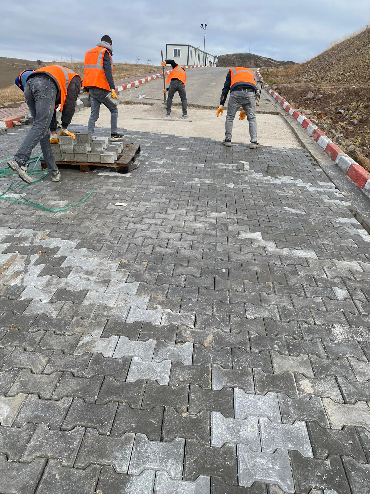 İşçiler tarafından döşenen gri 8 cm ağır yük kilitli parke taşları