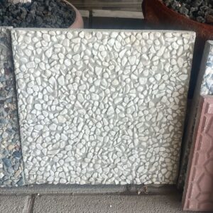 Tamamen beyaz çakılların yüzeyini kapladığı, 40x40 cm ölçülerindeki wash beton karo örneği.