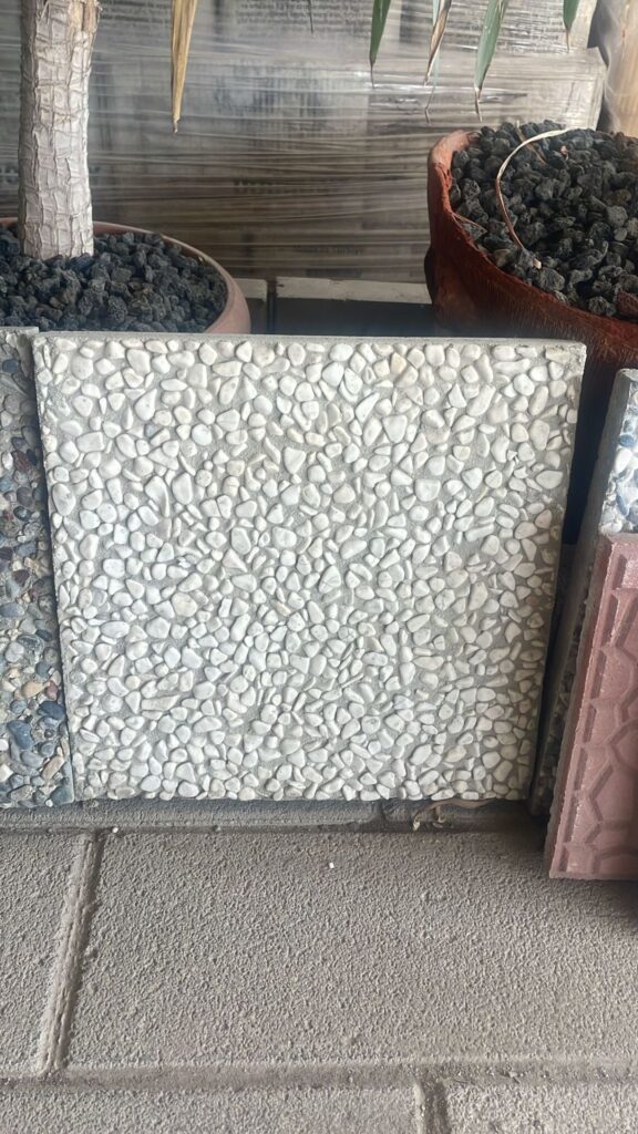 Tamamen beyaz çakılların yüzeyini kapladığı, 40x40 cm ölçülerindeki wash beton karo örneği.