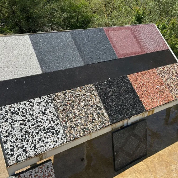 Beyaz çakıl, kırmızı çakıl, siyah agrega ve düz renkli wash beton karoların farklı modellerini gösteren dış mekan numune panosu.