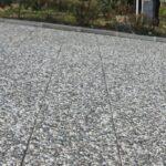 Farklı renk ve desenlerdeki çakıllı wash beton karoların (bina girişi, garaj yolu, bahçe zemini) uygulandığı dış mekan fotoğrafları.