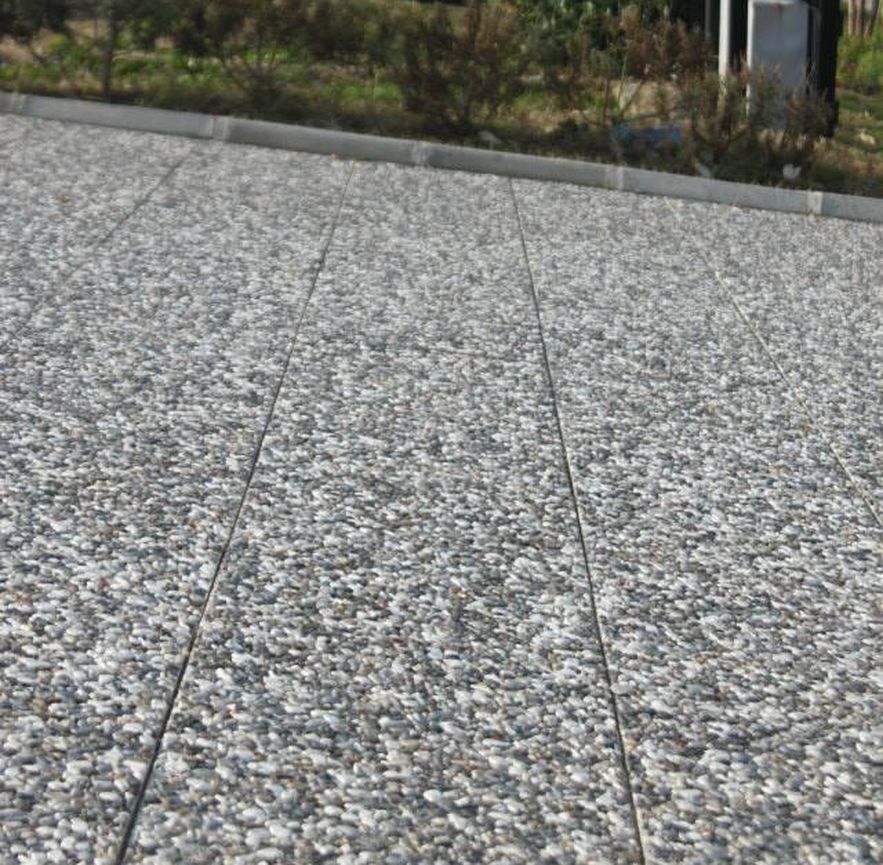 Farklı renk ve desenlerdeki çakıllı wash beton karoların (bina girişi, garaj yolu, bahçe zemini) uygulandığı dış mekan fotoğrafları.