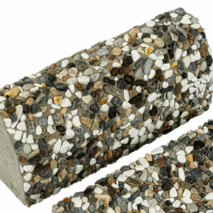 Yüzeyinde karışık renkli doğal çakılların belirgin olduğu, dikdörtgen formlu wash beton bordür taşının yakın çekim görüntüsü.