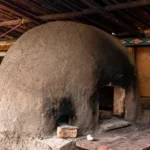 Doğal kayrak taşlarıyla kaplanmış, siyah metal kapaklı ve paslanmaz çelik bacalı hazır seyyar taş fırın.