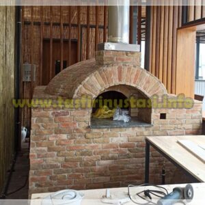 Doğal kayrak taşlarıyla kaplanmış, siyah metal kapaklı ve paslanmaz çelik bacalı hazır seyyar taş fırın. Malzeme kalitesini gösteren örnek model.