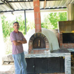 Kırmızı harman tuğlasından yapılmış, kemerli ağza ve kubbe çatılı pişirme bölümüne sahip, odunluk hazneli dış mekan fırını.