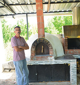 Kırmızı harman tuğlasından yapılmış, kemerli ağza ve kubbe çatılı pişirme bölümüne sahip, odunluk hazneli dış mekan fırını.