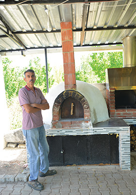 Kırmızı harman tuğlasından yapılmış, kemerli ağza ve kubbe çatılı pişirme bölümüne sahip, odunluk hazneli dış mekan fırını.