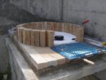 Beton kaide üzerinde refrakter ateş tuğlaları ile fırın kubbesinin ilk sırasının örülme aşaması. Ortada strafor kalıp ve yanda barbekü ızgarası.