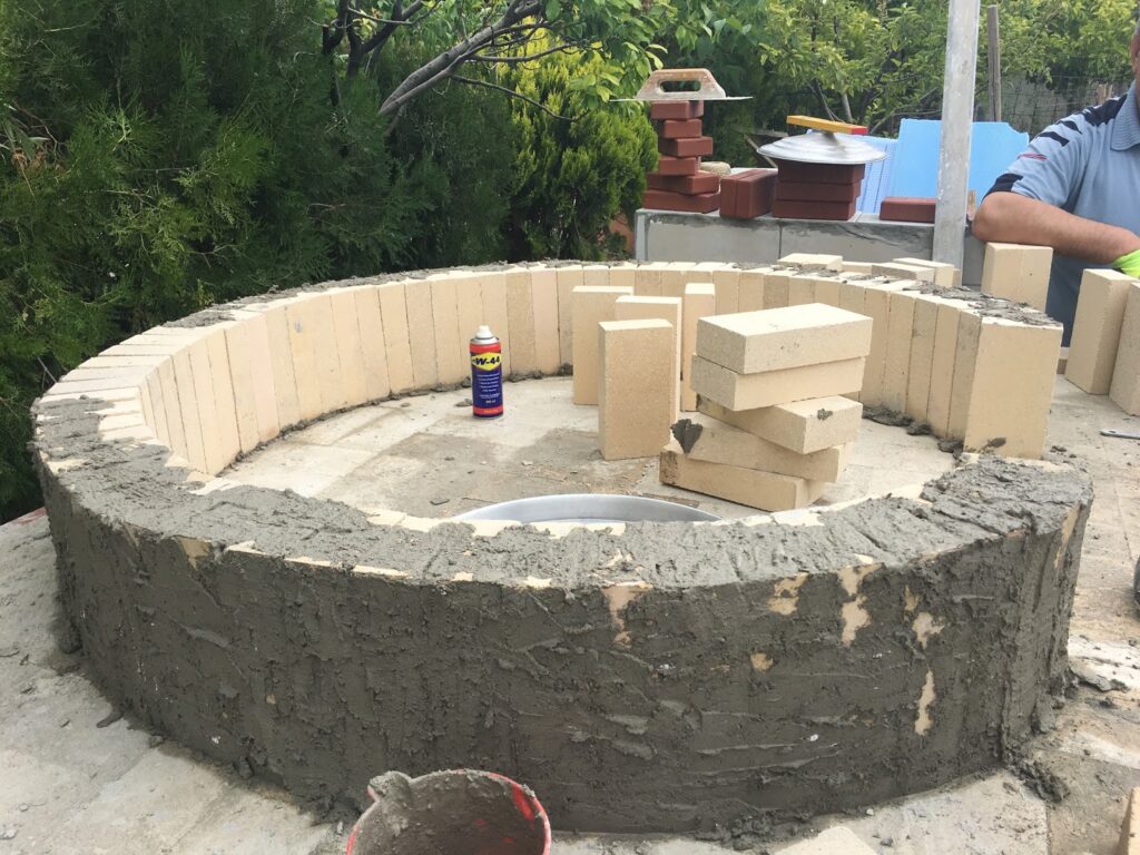 Briket kaide üzerine inşa edilmekte olan, tuğla ve çamurlu sıva ile örülen kubbe kısmı ve içerideki köpük destek kalıbı (ya da kum dolgusundan sonraki hali).