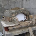 Tuğla kubbesi örülmüş ve sıva ile kaplanmaya başlanmış, kubbe ağzında köpük kalıp desteği bulunan yarım inşa edilmiş köy fırını.