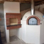 Beyaz sıvalı, kırmızı tuğla kemerli fırın ağzı ve paslanmaz çelik bacalı entegre köy fırını. Yan kısımda tuğla kaplamalı barbekü (ızgara) alanı.