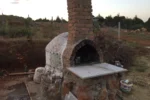 Killi toprak üzerinde, tuğla bacalı ve kubbesi mozaik kaplama detayıyla tamamlanmaya yakın hobi bahçesi fırını.