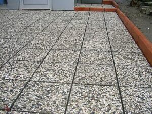 Farklı renk ve dokularda (Siyah, Beyaz, Karışık Çakıllı) wash beton karo numuneleri ve otopark/bina girişi gibi dış mekan uygulama örnekleri.