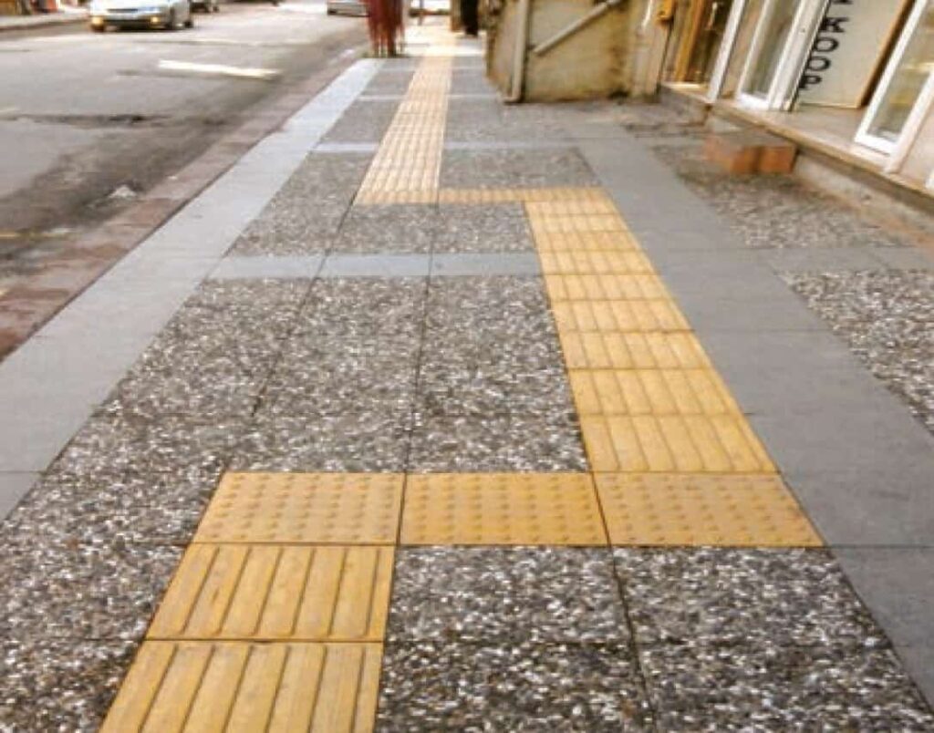 Farklı renk ve desenlerdeki (beyaz, siyah, karışık çakıl) wash beton karoların palet stok ve dış mekan zemin (kaldırım, bahçe, dama deseni) uygulama örnekleri.