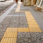 Farklı renk ve desenlerdeki (beyaz, siyah, karışık çakıl) wash beton karoların palet stok ve dış mekan zemin (kaldırım, bahçe, dama deseni) uygulama örnekleri.