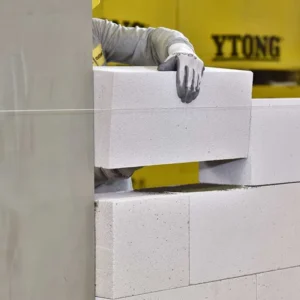 İnşaat işçisi tarafından iple hizalanarak örülen beyaz renkli ytong gazbeton duvar blokları.