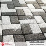 Açık gri ve koyu antrasit renkli 10x20 prizma parke taşları ile çapraz desende döşenmiş mineral yüzeyli zemin.