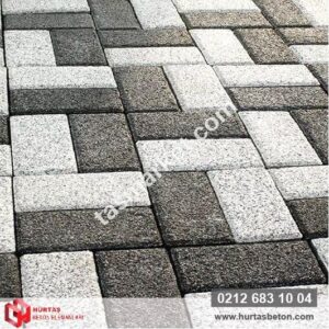 Açık gri ve koyu antrasit renkli 10x20 prizma parke taşları ile çapraz desende döşenmiş mineral yüzeyli zemin.