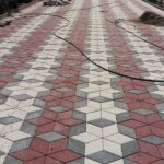 Kırmızı, beyaz ve gri renkli 3D görünümlü kilitli parke taşlarıyla döşenmiş estetik zemin.