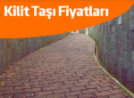 Kırmızı kilitli parke taşlarıyla döşenmiş kıvrımlı yürüyüş yolu. 6 cm aşık taşı fiyatları.