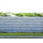 Patlatma briket kaplamalı hazır bahçe duvar paneli uygulaması. Gri taş görünümlü kaplama ve kırmızı sütun detayı.