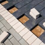 Siyah ve beyaz küp taşlarla yapılmış, dairesel dalga motifli, yüksek estetikli araç yolu kaplaması.