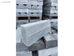 Kaldırım kenarı için kullanılan eğimli gri beton bordür taşları istifi
