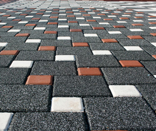 Siyah, beyaz ve kırmızı renkli 15x15 kumlamalı beton parke taşı zemin döşemesi.