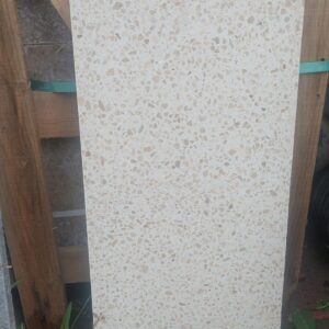 Palet üzerinde duran açık bej zeminli, kahverengi benekli 30x60 cm ölçülerinde terrazo zemin ve duvar karosu.