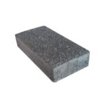 Beyaz zeminde koyu gri dokulu yüzeye sahip tek dikdörtgen beton parke taşı
