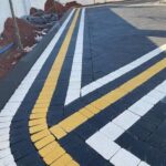 Koyu beton parke zeminde sarı ve beyaz kavisli bantlarla oluşturulmuş desen
