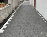 Koyu kare parke ve açık kenar taşlarıyla düzenlenmiş geçiş yolu