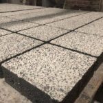 Açık renkli agregalı kare beton parke taşlarının yüzey ve kenar detayı