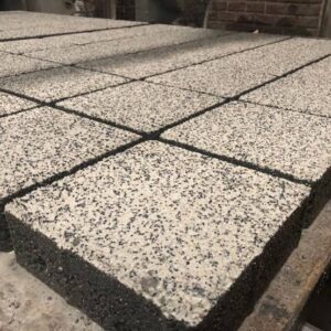 Açık renkli agregalı kare beton parke taşlarının yüzey ve kenar detayı