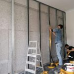 İç duvar önünde levha ve metal profillerle yalıtım uygulaması yapan ekip